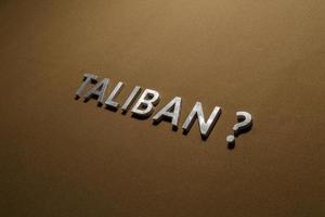 the question taliban laid with silver metal letters on rough tan khaki canvas fabric photo