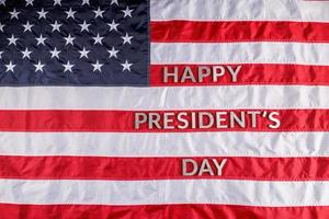 palabras feliz día del presidente colocadas con letras reales en la superficie de la bandera estadounidense foto