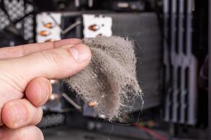 bare caucasian hand removing dust clog fromf opened pc case during maintenance photo