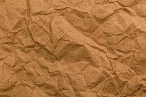 Ragged crumpled brown kraft paper texture and full frame background photo