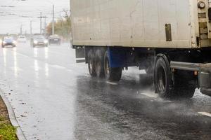 dry van trailer truck moving on a wet road with splashes during the day photo