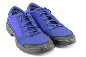 un par de zapatos de viaje de tela duradera y barata azul aislados en fondo blanco foto