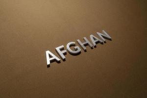 la palabra afgano colocada con letras de metal plateado sobre una tela de lona caqui tostada foto