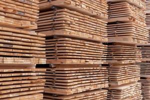 large stacks of wooden planks full frame background with selective focus and linear perspective photo