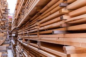 large stacks of wooden planks background with selective focus and linear perspective. Winter oudoor storage. photo