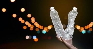 Giving plastic bottle to make recyclying, reusing and reducing objects to lower garbage and to keep our environment clean and clear to everyone concept, soft and selective focus. photo