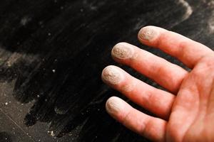 caucasian hand with dust on finger tips after touching black dusty surface photo