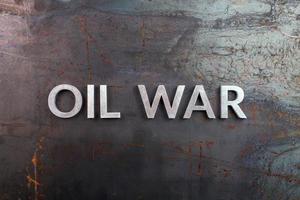 words oil war laid in line with silver metal letters on rusted heavy hot rolled uncoated steel sheet surface - directly above photo