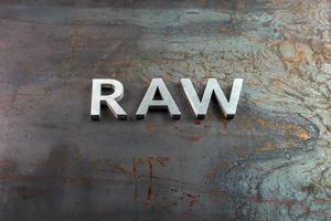 the word raw laid with silver metal letters on hot rolled steel sheet surface photo