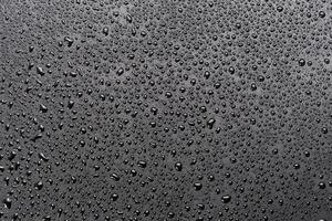 water drops on abstract flat black hydrophobic surface macro background photo