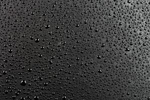 water drops on abstract flat black hydrophobic surface macro background photo