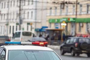 police car lights in city street with civilian cars traffic in blurry background in Tula, Russia photo