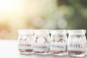 Message in a piece of paper and coins in a glass jar, money saving ideas, financial growth, retirement preparations, managing savings for different goals in the future, creating spending habits. photo