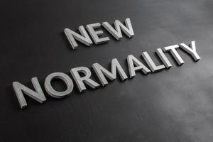the words new normality laid with silver metal letters on flat black matte surface in slanted diagonal perspective photo