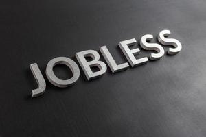 the word jobless laid with white scratched metal letters on flat black surface photo