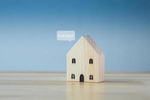 House for sale. Real estate agent, Property investment. Home purchase dealing. Wooden house model with speech bubble FOR SALE. photo