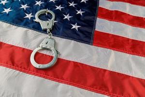 silver metal handcuffs over US flag on flat surface photo