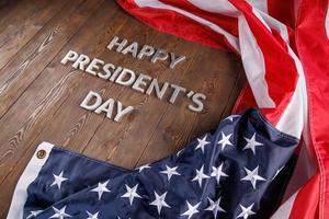 words happy presitdents day laid with real letters on wooden board near US flag photo