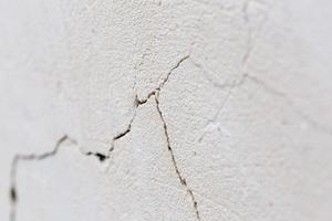 closeup background of cracked light porple plaster wall with selective focus and naturla blur photo