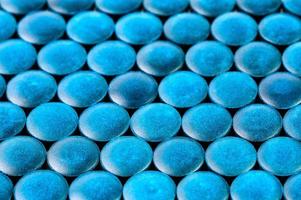 close-up background of many blue organic spirulina tablets laid tight in one layer on flat surface photo