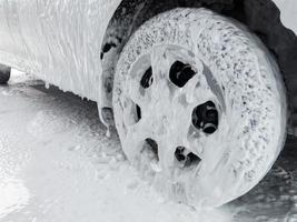 close-up view of car at carwash covered with soap sud photo