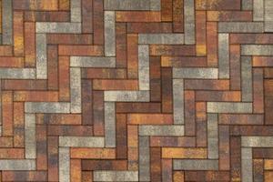 texture and full frame background of brown, yellow and grey parquet artificial stone pavement photo