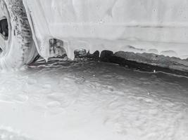 close-up view of car at carwash covered with soap sud photo