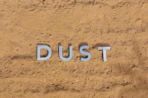 la palabra polvo en la superficie de la carretera polvorienta en perspectiva plana foto