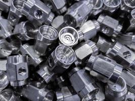 pile of abstract industrial close-up full frame background of shiny steel turned hexagonal parts photo