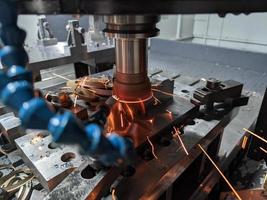 cnc milling of hardened steel with sparks - closeup with selective focus and blur photo