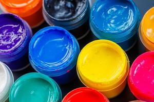 full-frame close-up background of opened small gouache paint jars photo