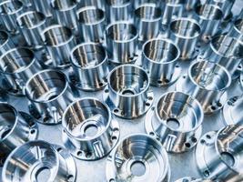 a batch of shiny metal cnc aerospace parts production - close-up with selective focus for industrial background photo