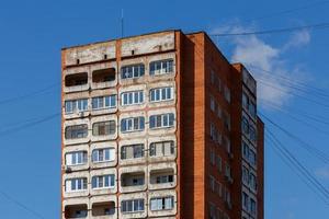 Típico edificio residencial de condominios de torre de hormigón y ladrillo de Rusia media sobre fondo de cielo azul foto