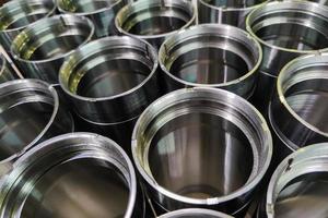 a close-up shot of shiny steel aerospace cnc turned tubes in a batch with selective focus and background blur photo