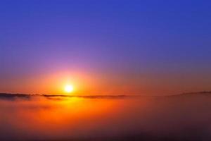 golden-blue summer sunrise over fog without clouds in minimalistic composition photo