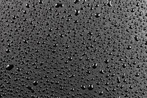 water drops on abstract flat black hydrophobic surface macro background photo