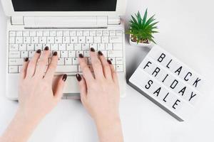 Black friday sale concept. Woman buys online using laptop. photo