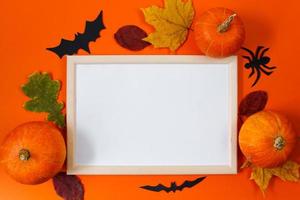 Halloween concept. Festive decorations. Pumpkins and greeting card on orange background. photo