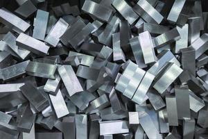 a pile of shiny faceted steel blocks - full frame close-up with selective focus photo