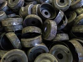 heap of dirty black stamped metal round shells after a hood operation photo