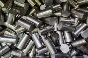 a pile of saw cutted stainless steel rods with metal sawdust - closeup with selective focus photo