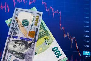 dollar and euro banknotes over digital screen with exchange chart, USD EUR parity concept photo