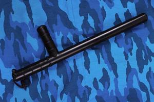 black rubber baton on blue urban russian riot police camouflage flat lay photo