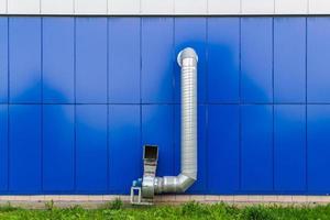 conducto de extracción de aire de grado industrial con motor eléctrico en la pared azul foto