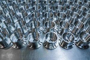 a batch of shiny metal cnc aerospace parts production - close-up with selective focus for industrial background photo