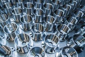a batch of shiny metal cnc aerospace parts production - close-up with selective focus for industrial background photo