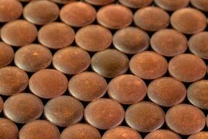 close-up background of many orange organic powder tablets laid tight in one layer on flat surface photo