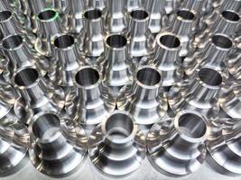 a batch of shiny steel cnc aerospace parts production - close-up with selective focus for industrial background photo