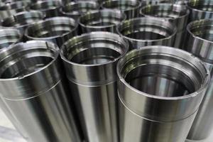 a close-up shot of shiny steel aerospace cnc turned tubes in a batch with selective focus and background blur photo