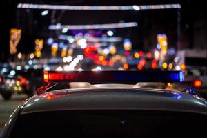 luces de coches de policía por la noche en la ciudad con enfoque selectivo y bokeh foto